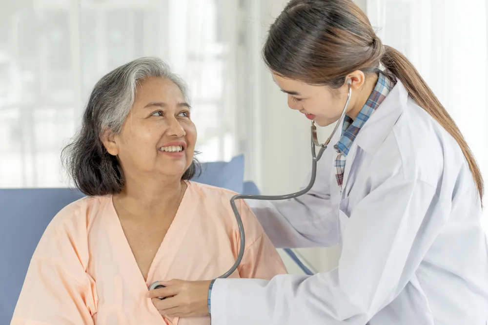 A doctor checking an elderly woman with a stethoscope