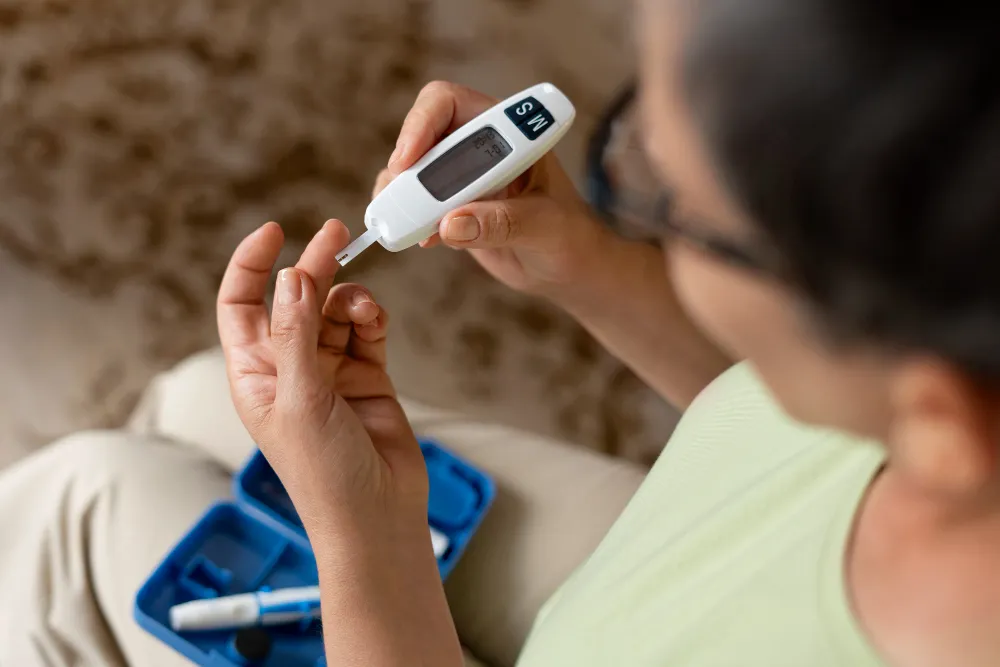 A person checking blood sugar with a glucometer