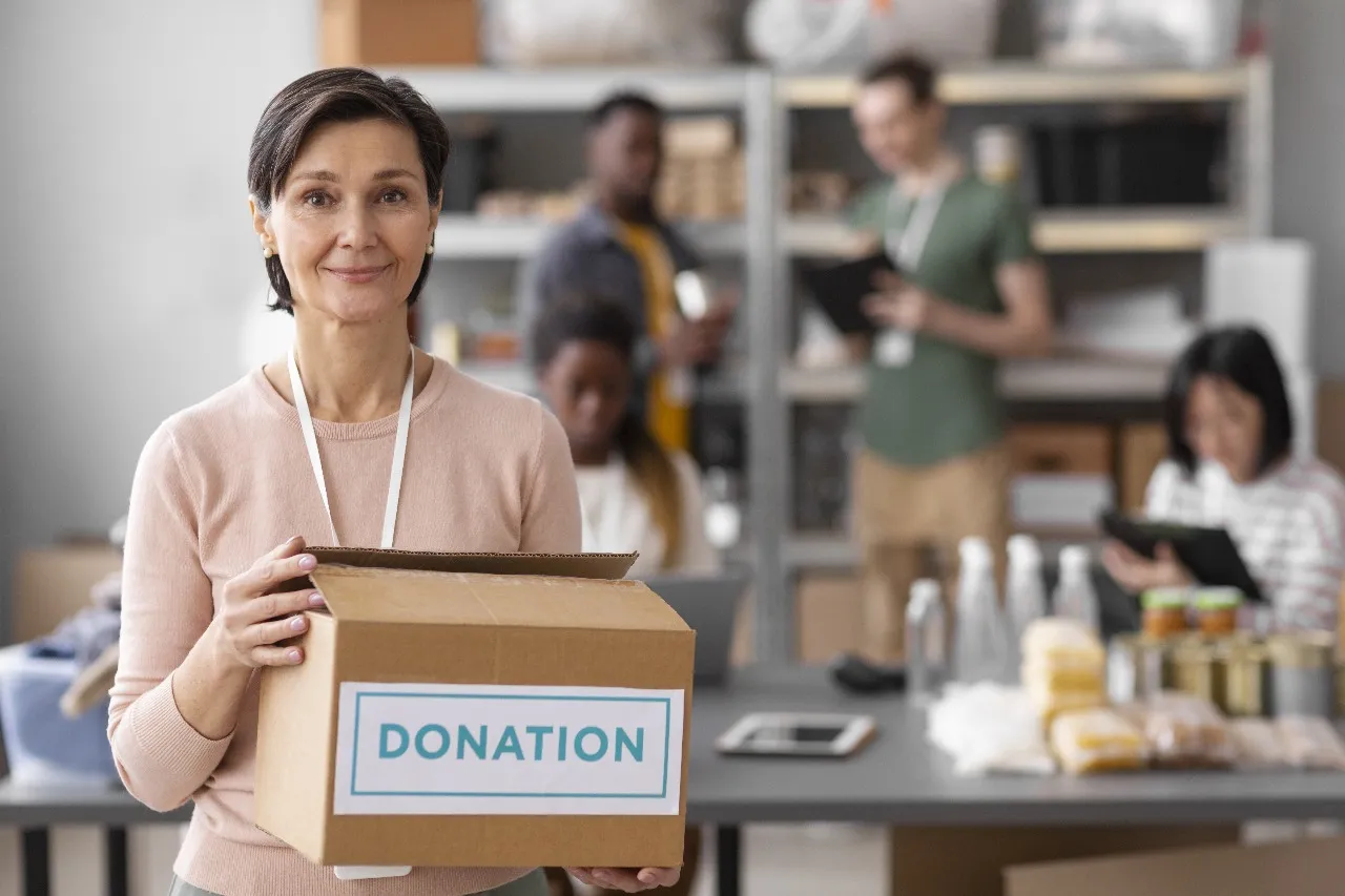 A volunteer holding a donation box