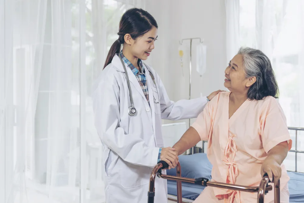 A doctor helping an elderly patient walk