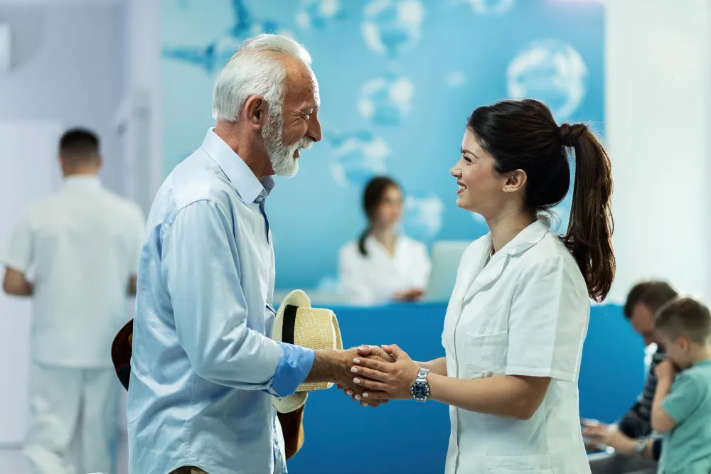 A volunteer greeting an elderly man at a clinic